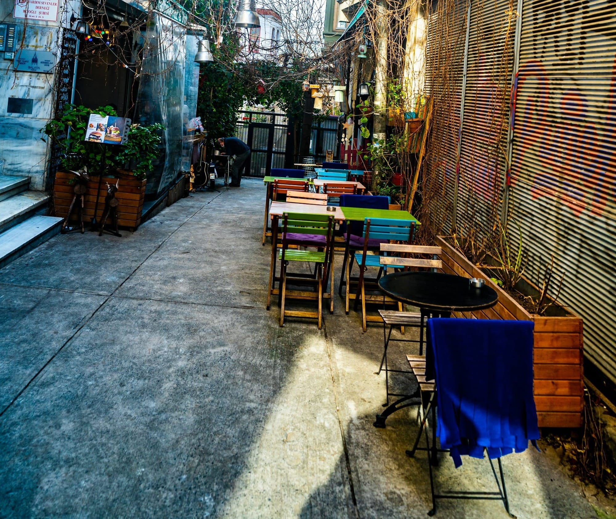 a narrow alleyway with tables and chairs